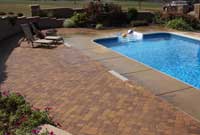 Paver patio with pool surrounded by retaining wall and privacy concrete two sided fence